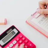 Różowa kalkulatorka pokazuje 39. Obok leży gumka. Dłoń pisze na notatniku: 25+14=39. Od ilu procent jest 5?