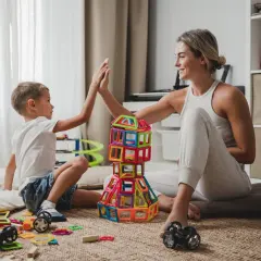 Mama i syn budują wieżę z klocków, świętując sukces. Wspaniałe zabawy dla dzieci w domu!