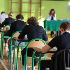 Uczniowie siedzą w ławkach podczas egzaminu.