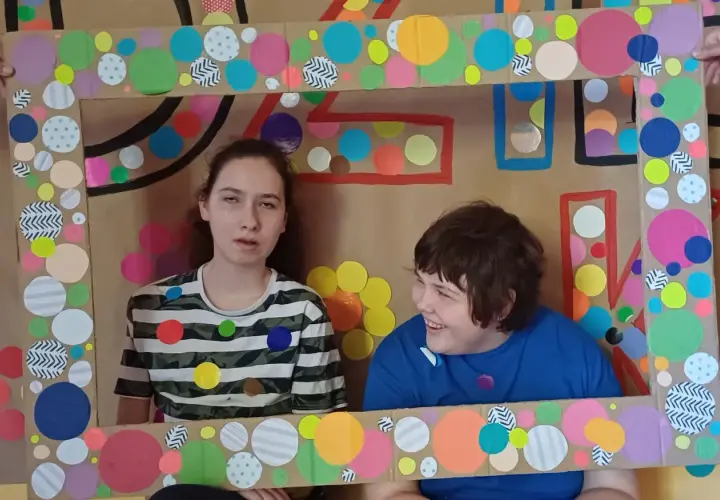 Dwie dziewczynki w ramie z kolorowych kółek.