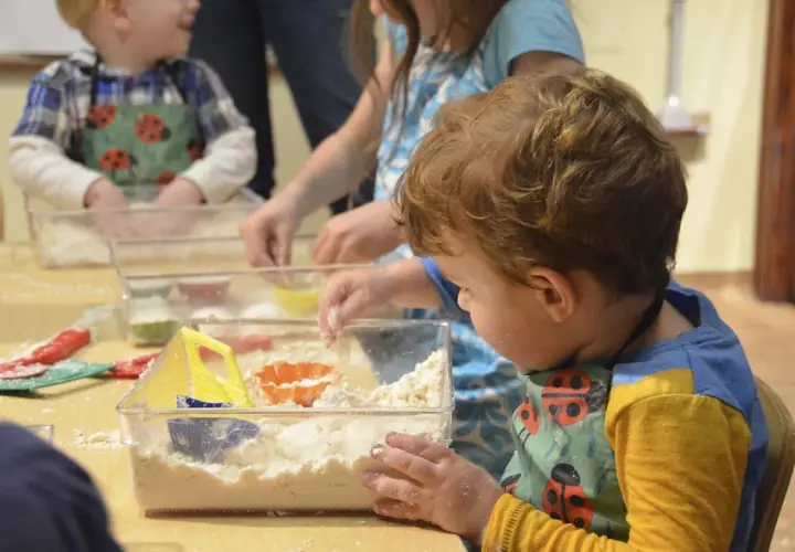 Dzieci bawią się masą sensoryczną, tworząc własne światy. Świetne zajęcia sensoryczne pomysły na kreatywną zabawę.