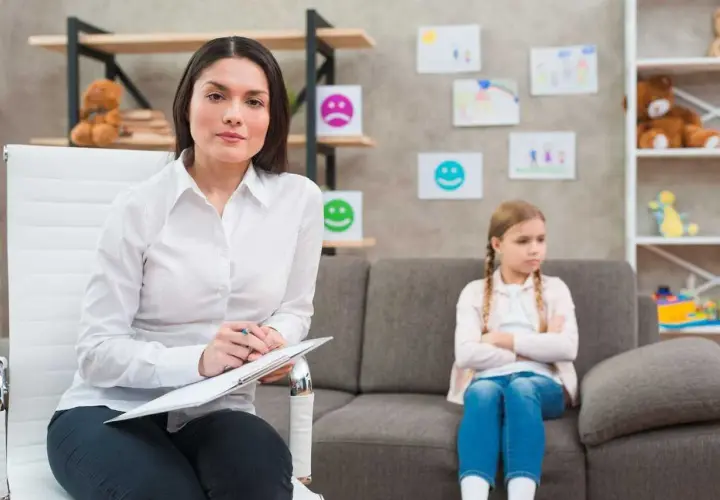Psycholog z notatkami podczas sesji z dzieckiem. To przykład przygotowania pedagogicznego dla psychologów, wspierającego rozwój emocjonalny najmłodszych.