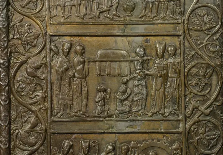 Fragment Drzwi Gnieźnieńskich: scena z postaciami w strojach historycznych i ornamentem roślinnym.