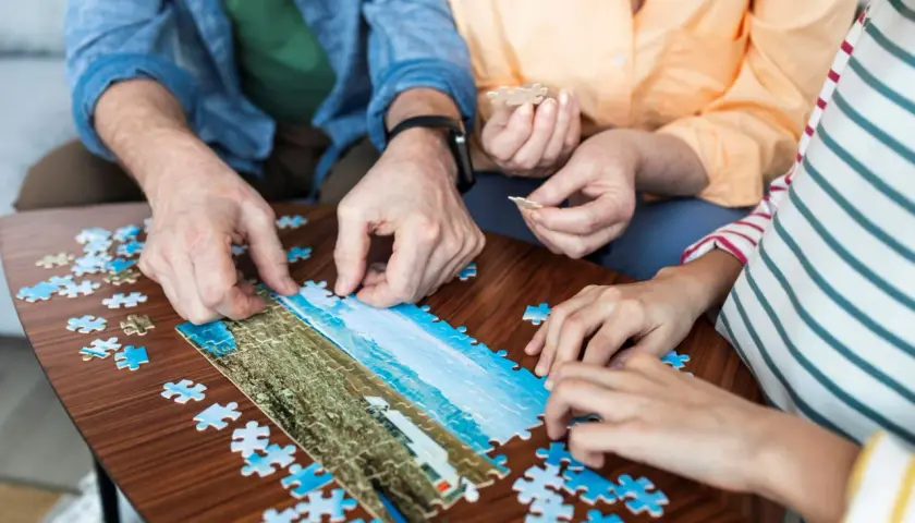 Wspólne układanie puzzli to świetne pomysły na zajęcia z seniorami. Radość z tworzenia obrazu z kawałków.