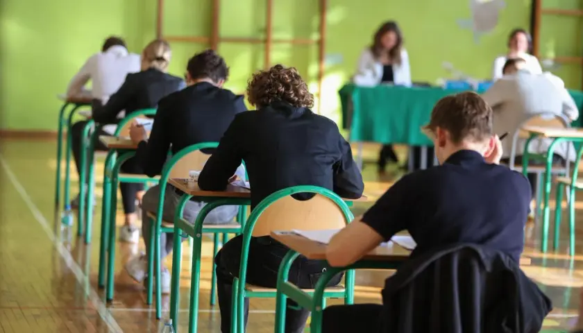 Uczniowie siedzą w ławkach podczas egzaminu.
