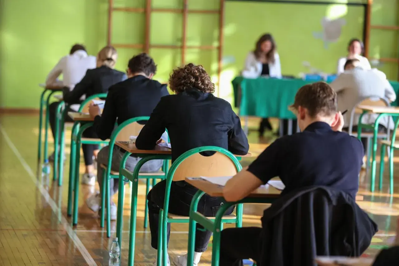 Uczniowie siedzą w ławkach podczas egzaminu.