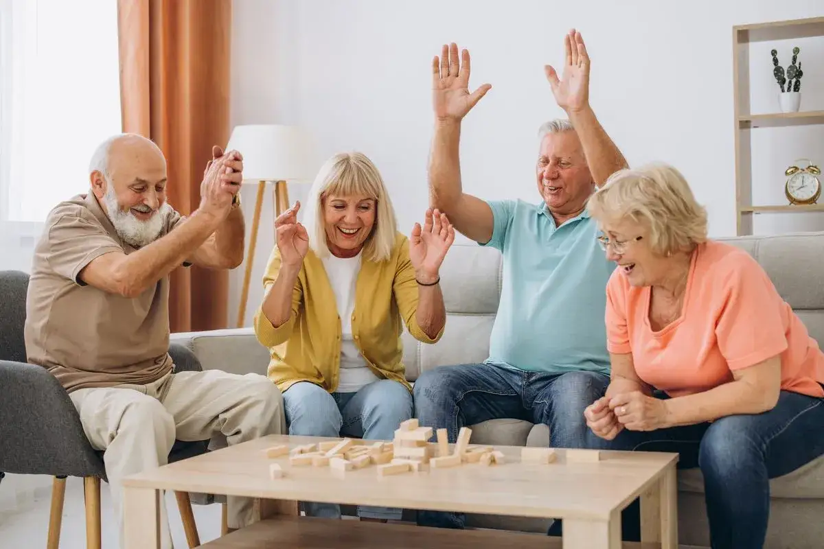 Radość i śmiech seniorów grających w Jengę. Świetne pomysły na zajęcia z seniorami, które budują więzi i dostarczają rozrywki.