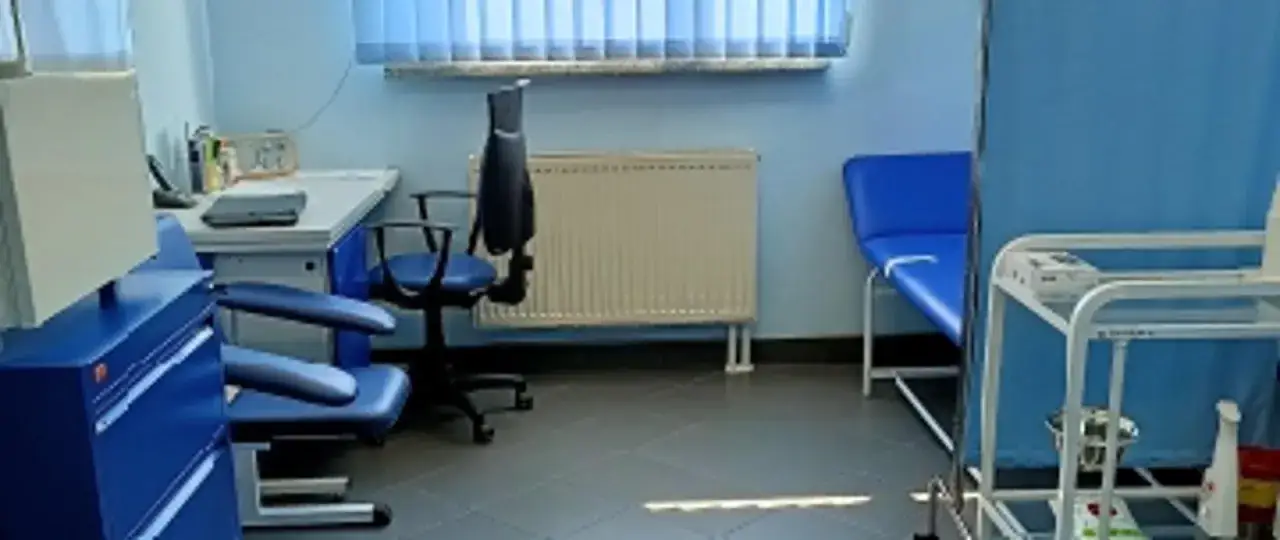 Gabinet pielęgniarki szkolnej z fotelem zabiegowym i kozetką. Tu można dowiedzieć się, jak obliczyć czas pracy pielęgniarki szkolnej.
